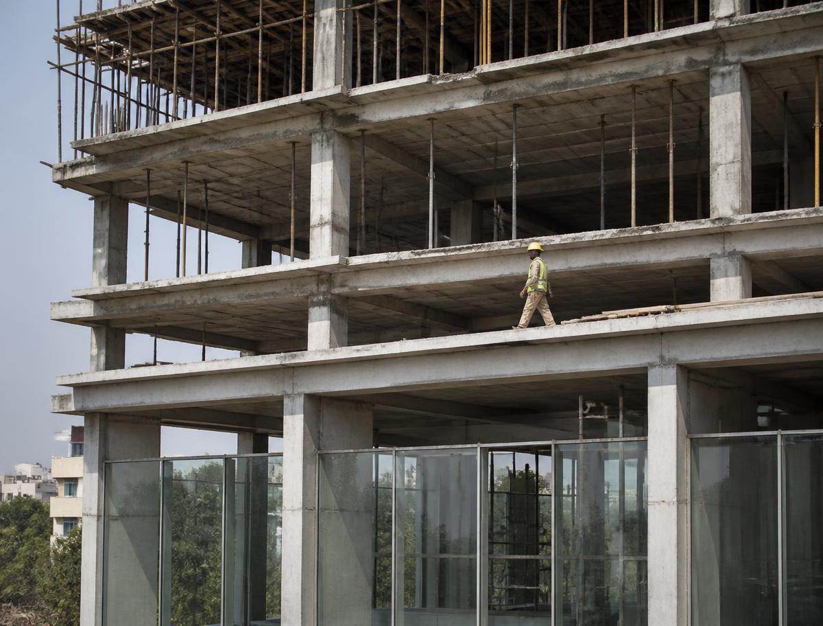 Modern multi-storey building under construction in Lahore with concrete frame, slab props and glazing on the lower floors